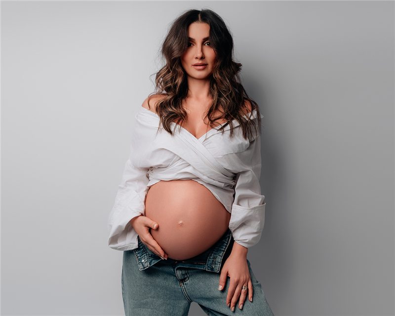 Dra. Roberta, médica da Mealth Clinic - que oferece consultas dermatológicas com foco em estética - na unidade do Cachambi e da Barra da Tijuca, grávida e acariciando sua barriga para o artigo sobre skincare para gestantes.
